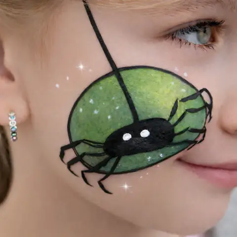 Green spider painted on a cheek