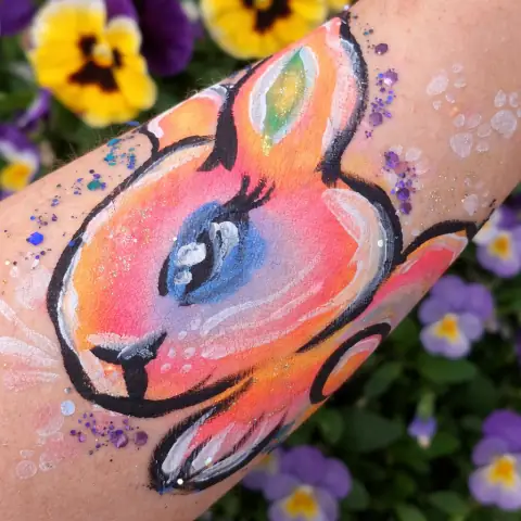Colorful rabbit painted on a cheek
