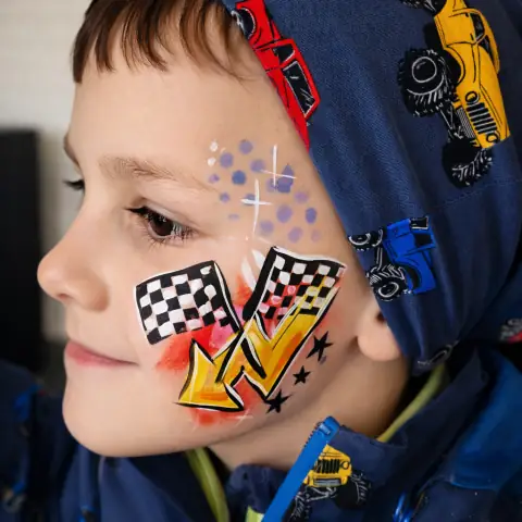 Racing cars painted on a boy's cheek