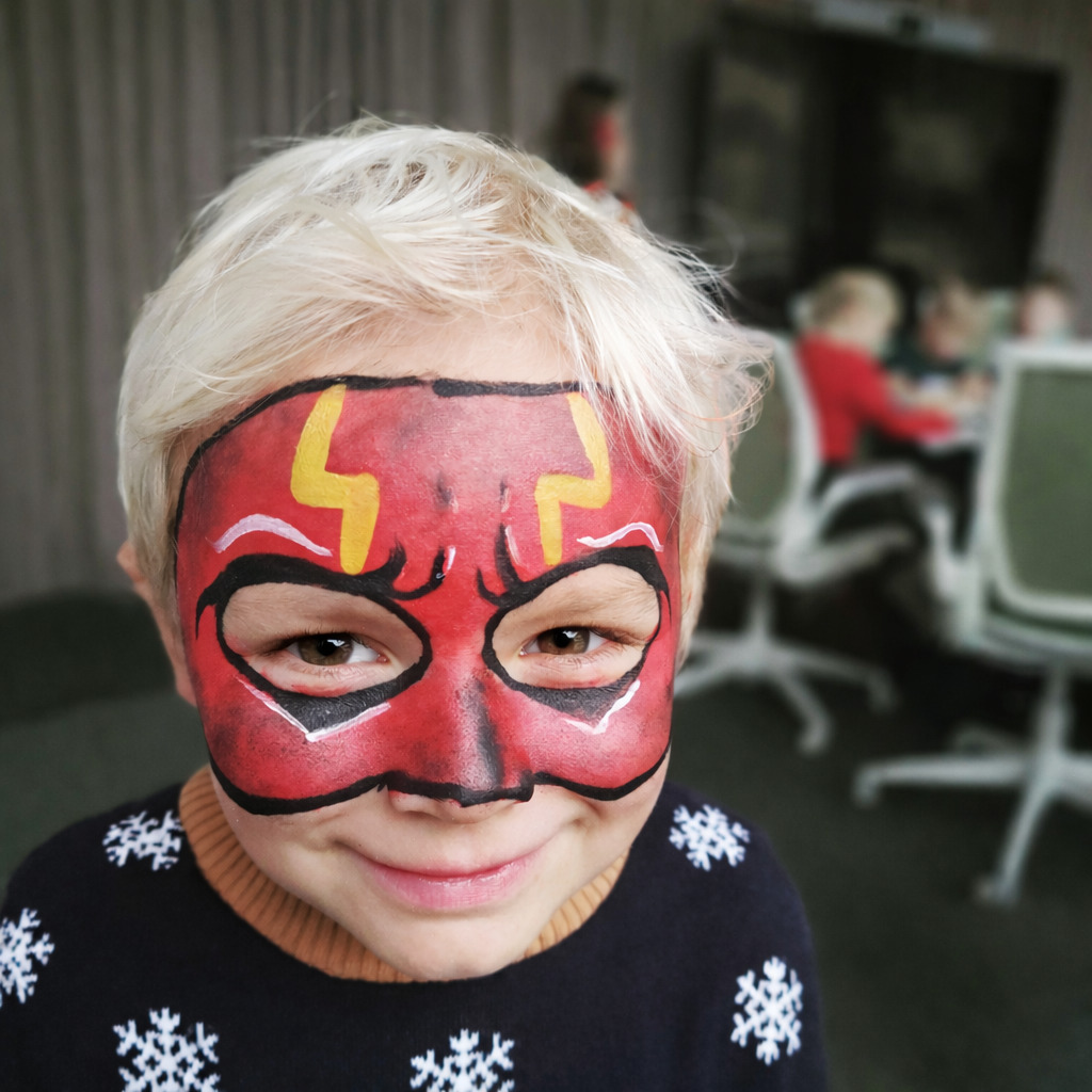 Boy with a red hero mask painted on his face